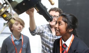 School children looking through telescope